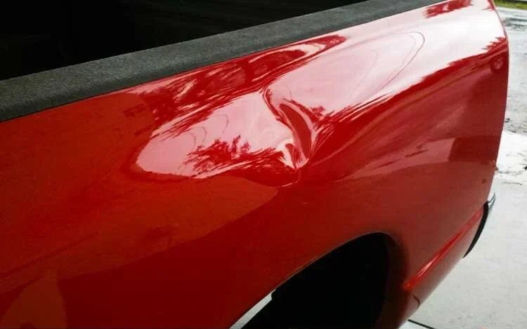 Close-up of a dent being assessed before repair