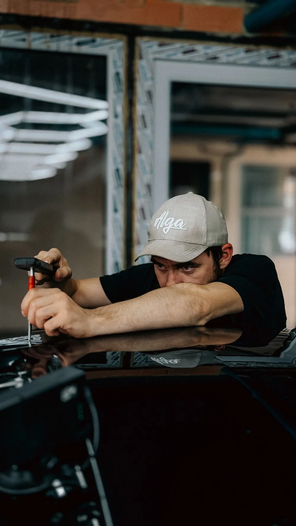 Technician working on a larger dent across a car panel